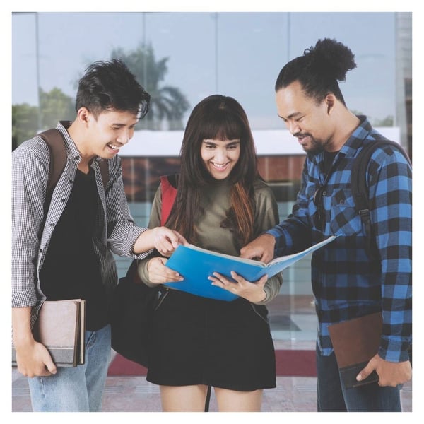Three students look at notes together